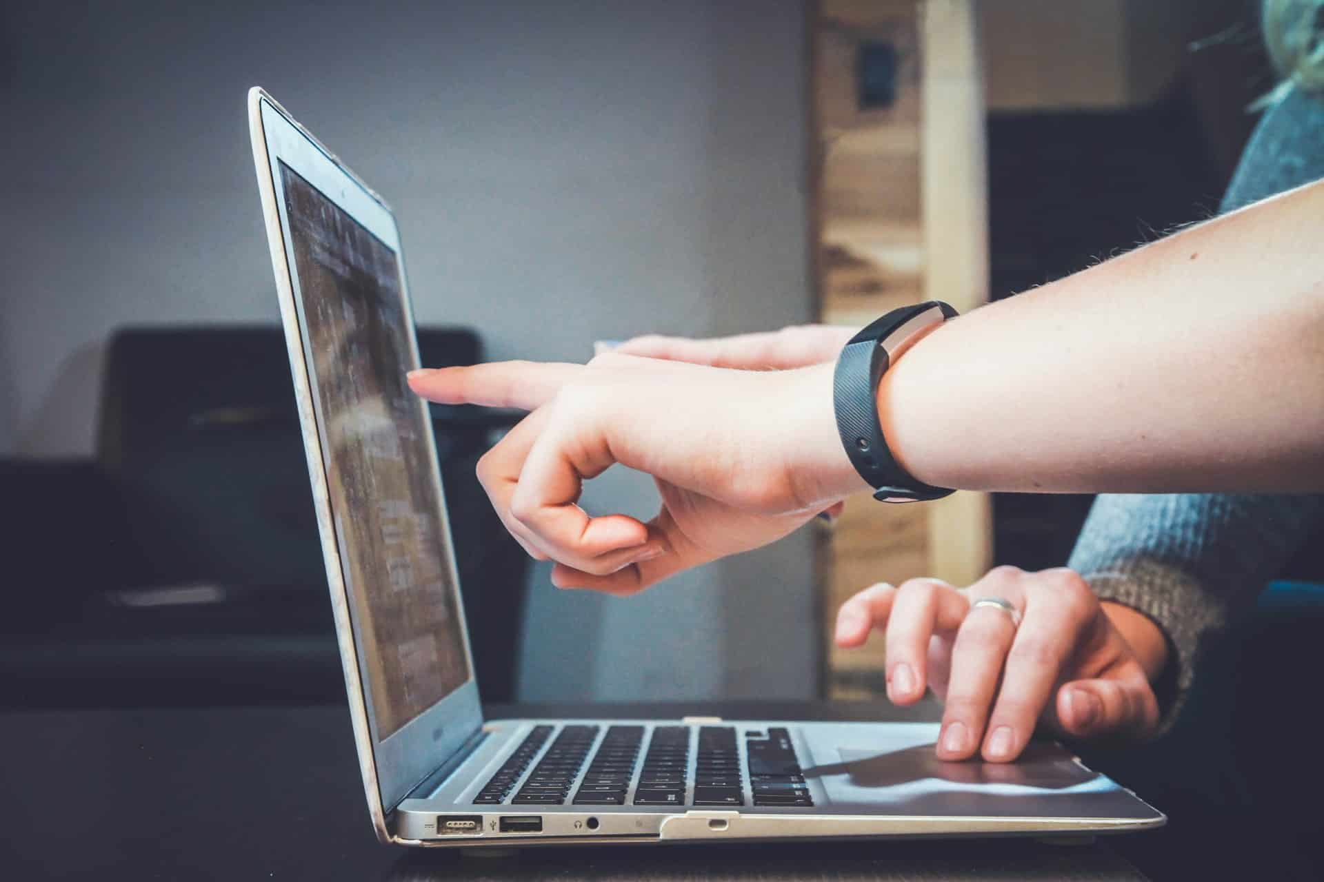 twee mensen helpen elkaar met laptop